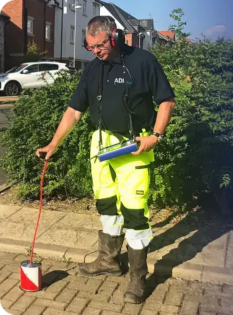 ADI engineer using acoustic listening equipment, with the ground sensor resting on the paving